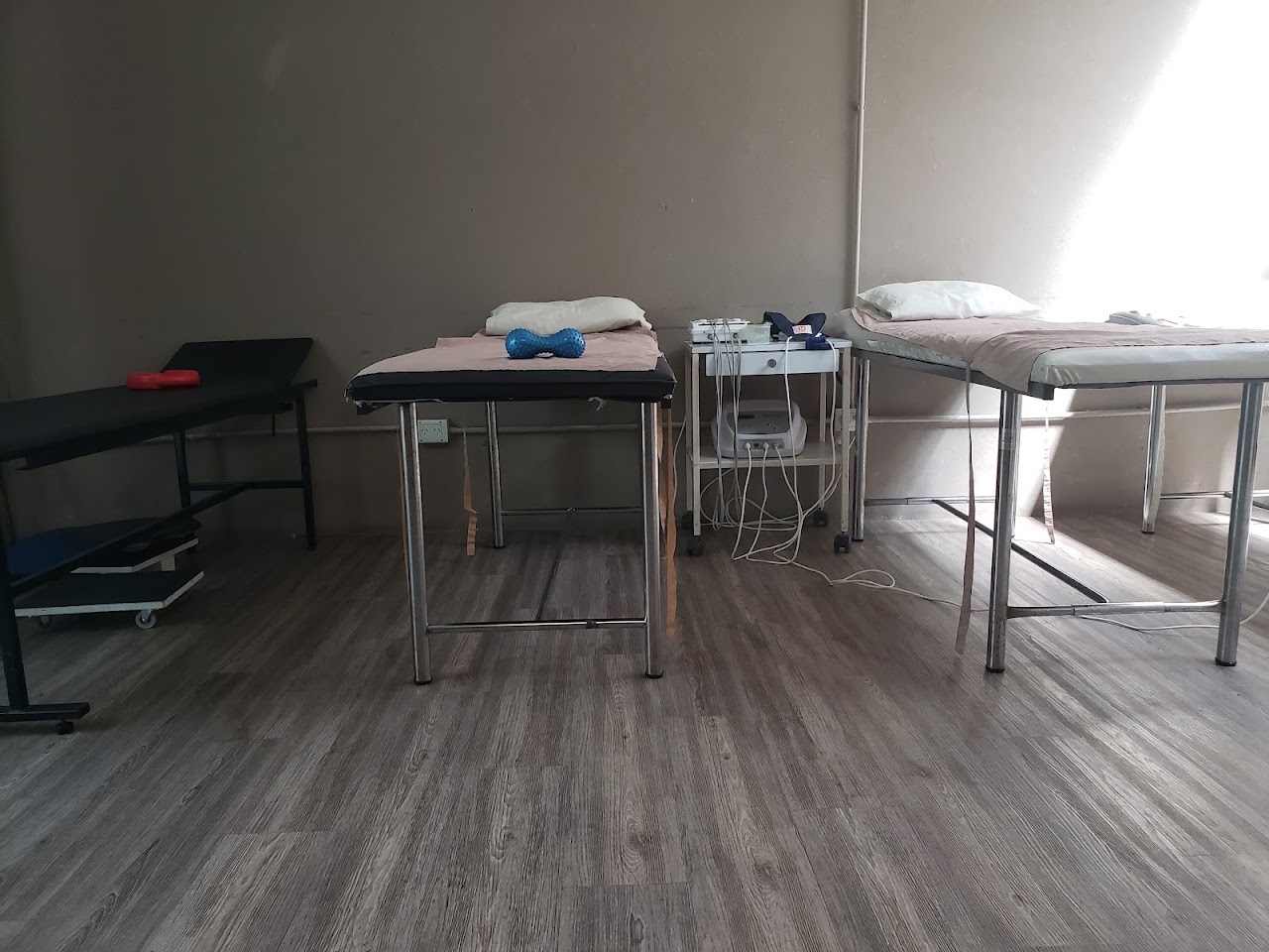 Sala de fisioterapia y electroestimulación con camilla médica y terapeuta en Life Kinesiología
